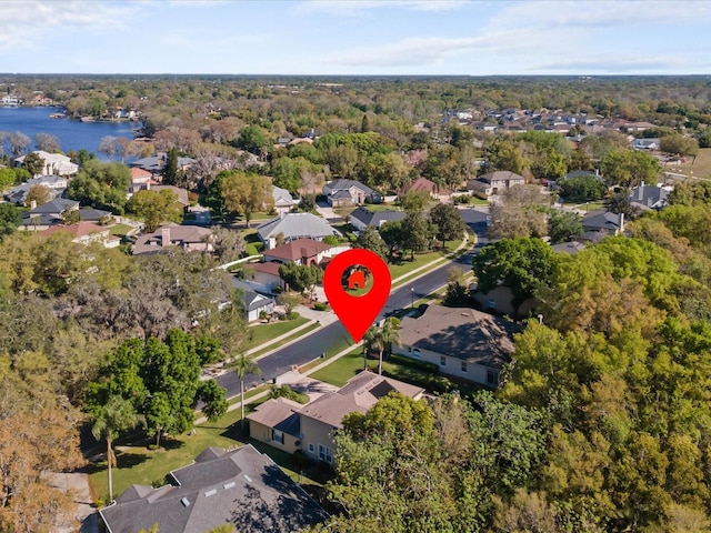 drone / aerial view with a residential view, a view of trees, and a water view