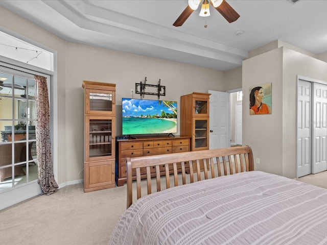 bedroom with ceiling fan, baseboards, a closet, and light carpet