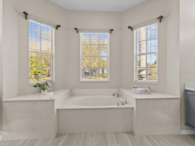 full bathroom with a bath and vanity