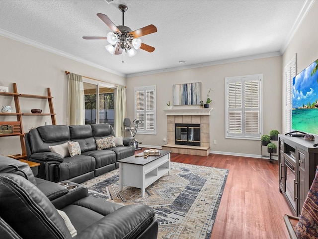 living room featuring wood finished floors, plenty of natural light, ceiling fan, and crown molding