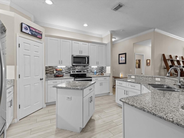 kitchen with wood tiled floor, a kitchen island, a sink, decorative backsplash, and stainless steel appliances