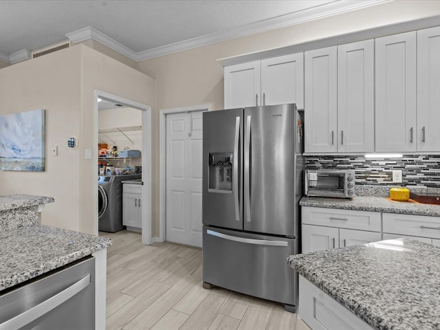 kitchen with visible vents, crown molding, a toaster, decorative backsplash, and stainless steel appliances