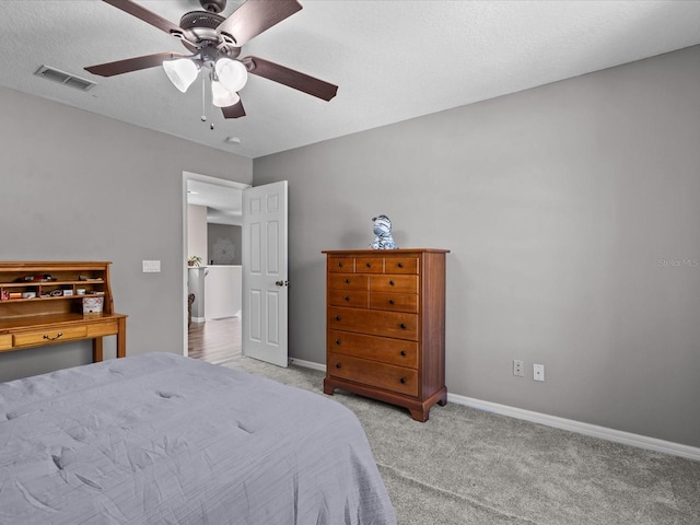 bedroom featuring a ceiling fan, baseboards, visible vents, carpet floors, and a textured ceiling