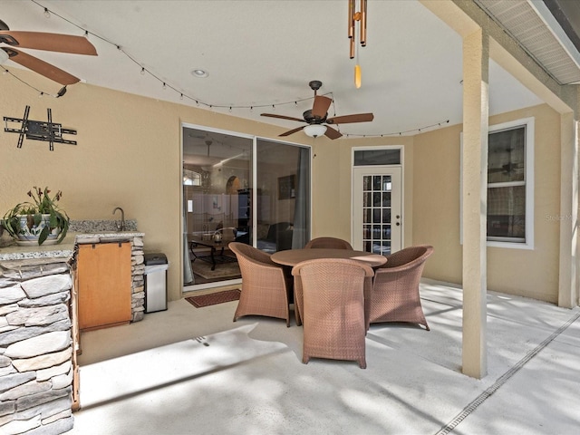 view of patio featuring a sink, ceiling fan, and outdoor dining space