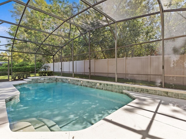 view of swimming pool with a lanai, a patio, a pool with connected hot tub, and a fenced backyard