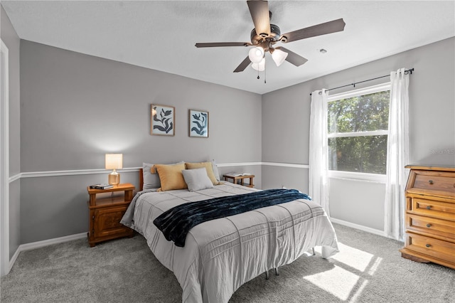 carpeted bedroom featuring baseboards and ceiling fan
