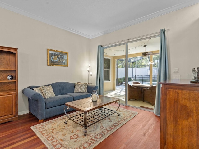 living area featuring wood finished floors, ornamental molding, and a ceiling fan