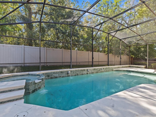 view of swimming pool featuring a fenced backyard, a lanai, and a pool with connected hot tub
