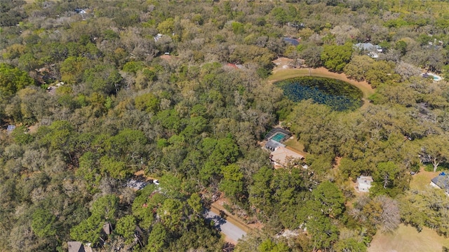 bird's eye view featuring a wooded view and a water view