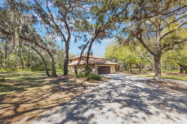 view of side of home with an attached garage and driveway