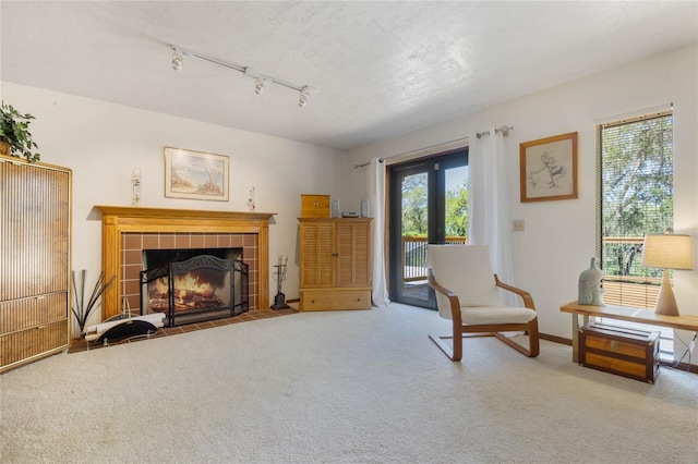 sitting room featuring track lighting, a tile fireplace, french doors, and carpet floors