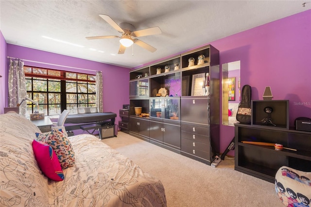 carpeted bedroom featuring a ceiling fan and a textured ceiling