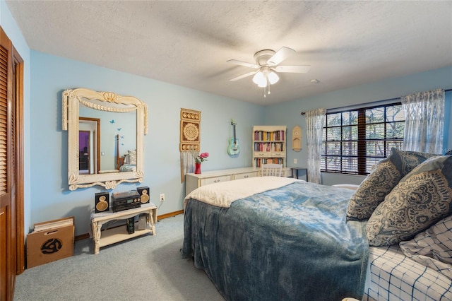 carpeted bedroom featuring a closet, baseboards, a textured ceiling, and ceiling fan