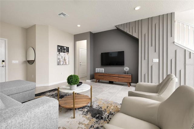 living area with light tile patterned floors, visible vents, and recessed lighting