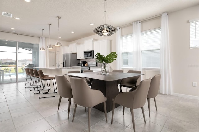 dining area featuring visible vents, baseboards, light tile patterned floors, recessed lighting, and a textured ceiling