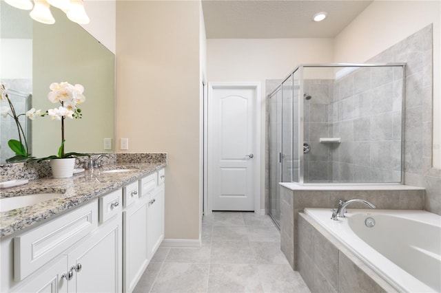 full bathroom featuring a shower stall, a garden tub, and a sink