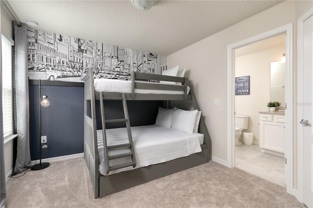 carpeted bedroom with ensuite bath, multiple windows, a textured ceiling, and baseboards