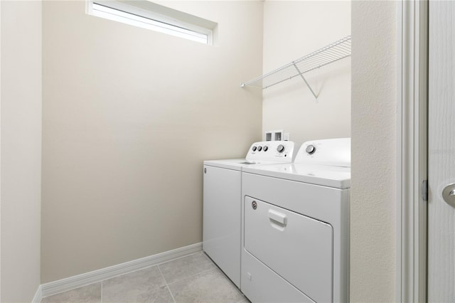 laundry room featuring light tile patterned floors, baseboards, separate washer and dryer, and laundry area