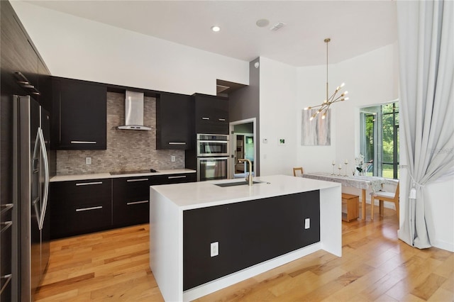 kitchen with wall chimney exhaust hood, modern cabinets, stainless steel appliances, and dark cabinetry