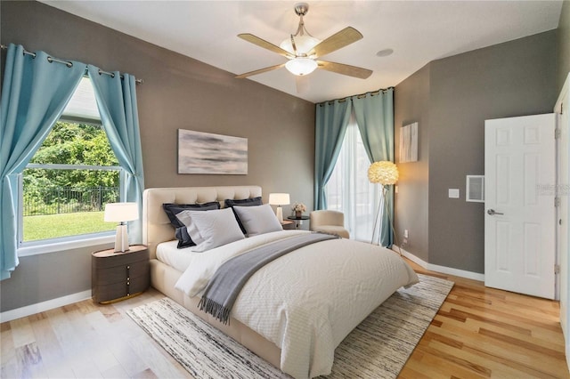 bedroom with baseboards, visible vents, and light wood finished floors