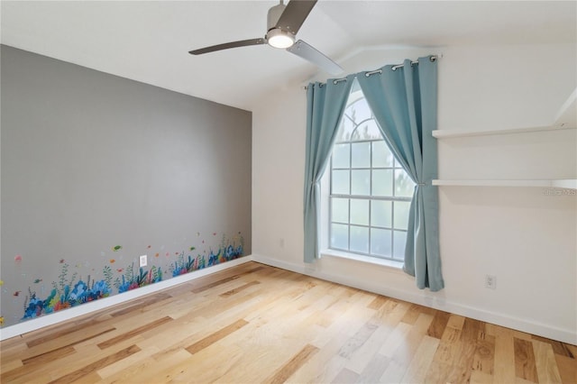 spare room with lofted ceiling, ceiling fan, baseboards, and wood finished floors