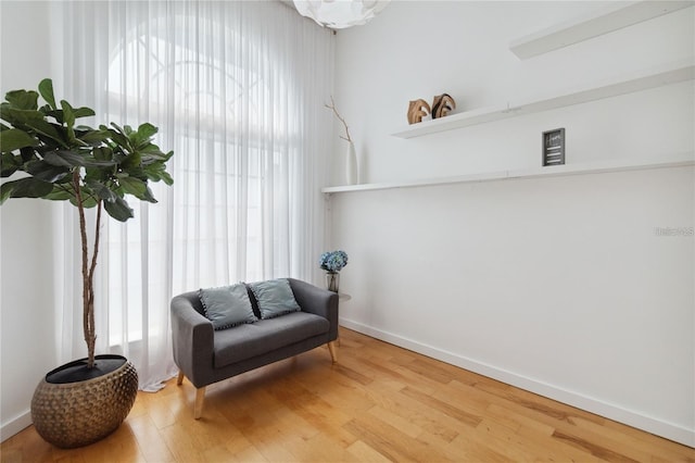 living area featuring baseboards and wood finished floors