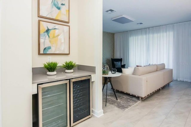 living area featuring a dry bar, beverage cooler, and visible vents