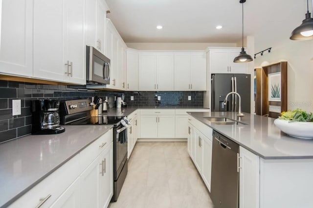 kitchen with an island with sink, white cabinetry, appliances with stainless steel finishes, and a sink