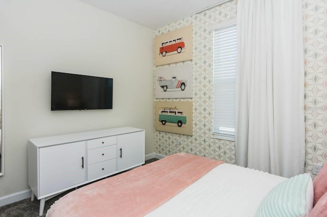 bedroom featuring wallpapered walls and baseboards