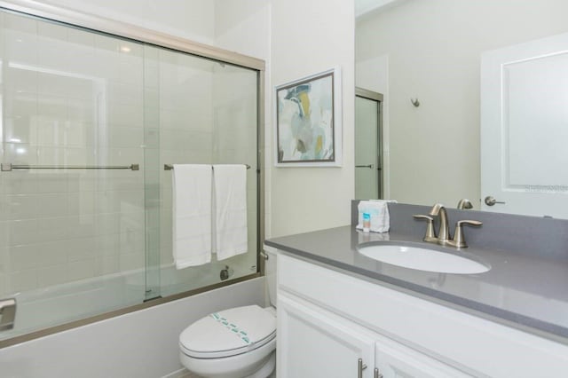 full bathroom featuring toilet, bath / shower combo with glass door, and vanity