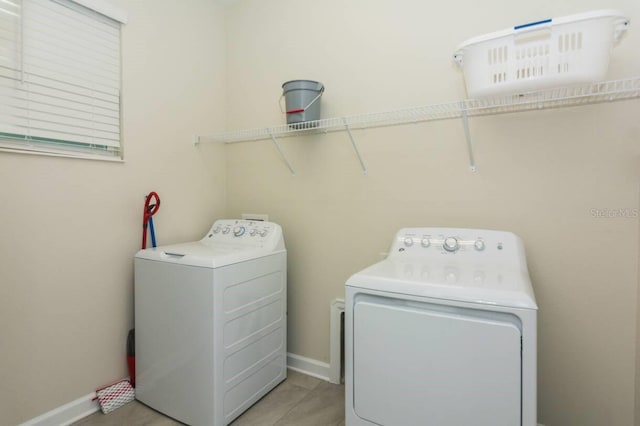 washroom featuring laundry area, baseboards, and independent washer and dryer