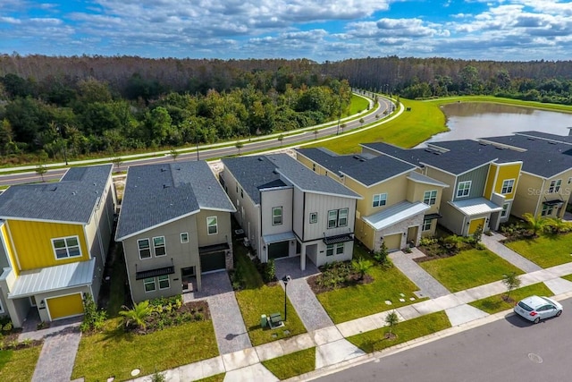 birds eye view of property featuring a residential view, a water view, and a wooded view