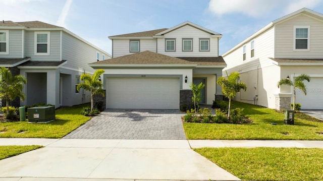 view of front facade with an attached garage, driveway, roof with shingles, and a front yard