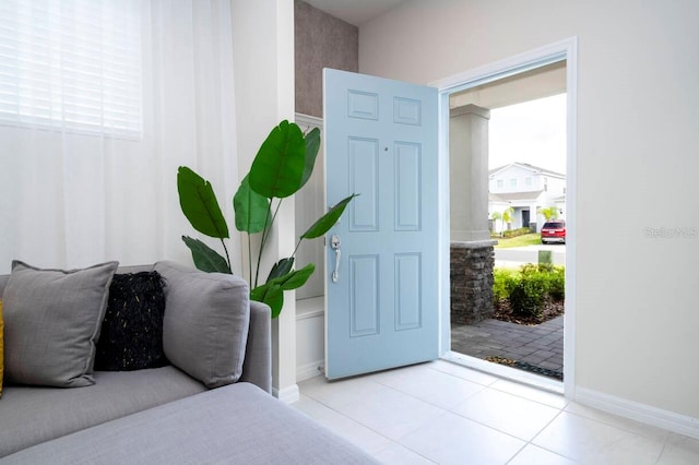 entryway with a wealth of natural light and light tile patterned flooring