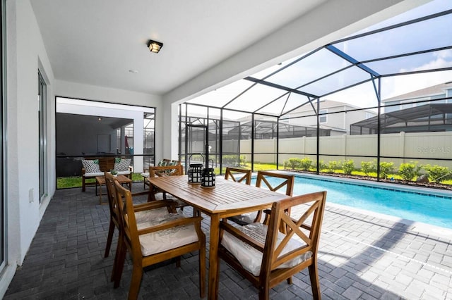 view of pool featuring a patio area, glass enclosure, a fenced in pool, and outdoor dining space