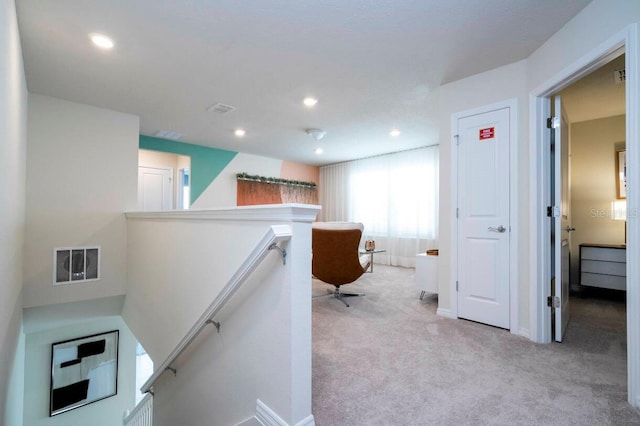 corridor with light carpet, recessed lighting, visible vents, and an upstairs landing