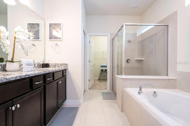 full bath featuring a stall shower, a garden tub, tile patterned flooring, a spacious closet, and vanity