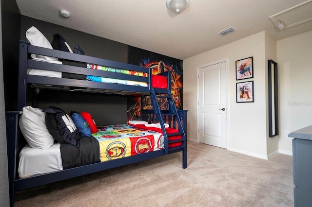 carpeted bedroom featuring baseboards, visible vents, and a textured ceiling