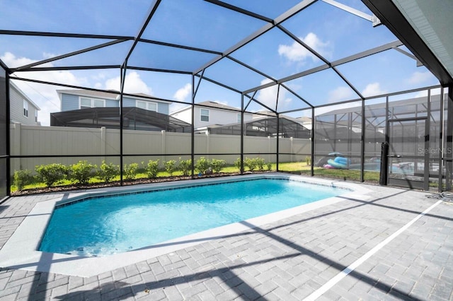 view of swimming pool with a fenced in pool, glass enclosure, a patio, and fence