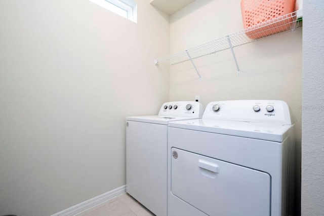 washroom with laundry area, baseboards, and washer and dryer