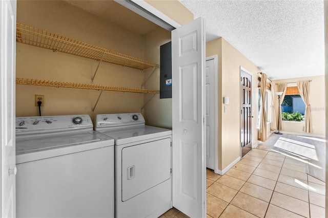 laundry room featuring a textured ceiling, laundry area, light tile patterned flooring, and washing machine and clothes dryer