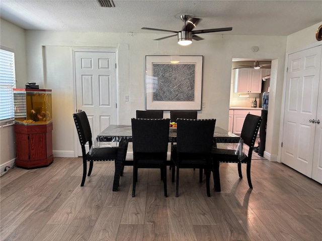 dining area featuring baseboards, ceiling fan, and wood finished floors