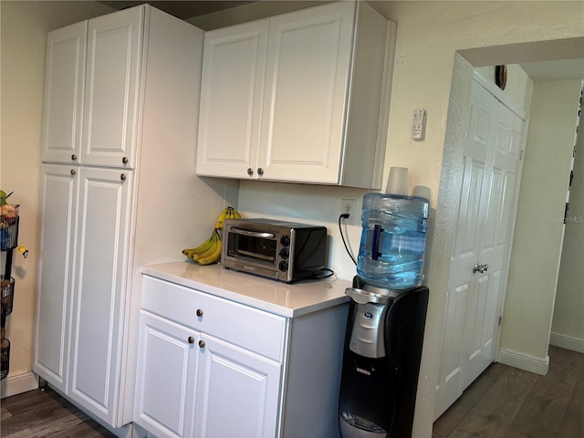 washroom featuring baseboards, dark wood-style floors, and a toaster