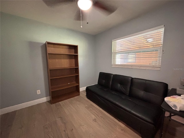 sitting room featuring baseboards, wood finished floors, and a ceiling fan