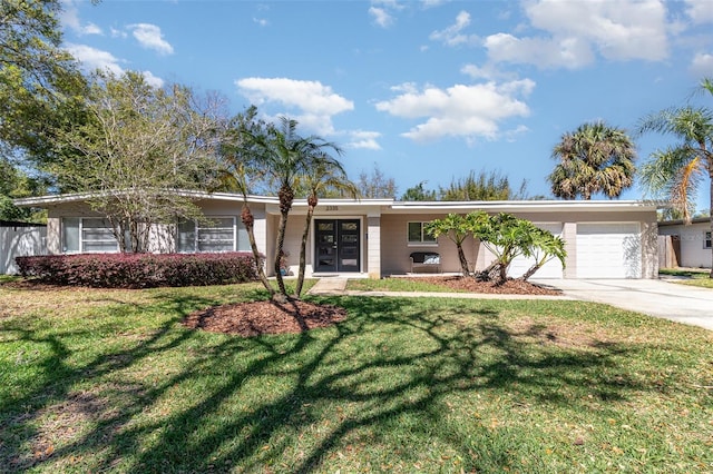 single story home with a front yard, concrete driveway, french doors, and a garage