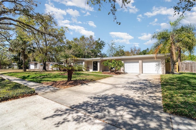 ranch-style house with stucco siding, driveway, a front lawn, fence, and a garage