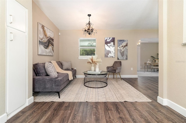 sitting room with baseboards, an inviting chandelier, and wood finished floors