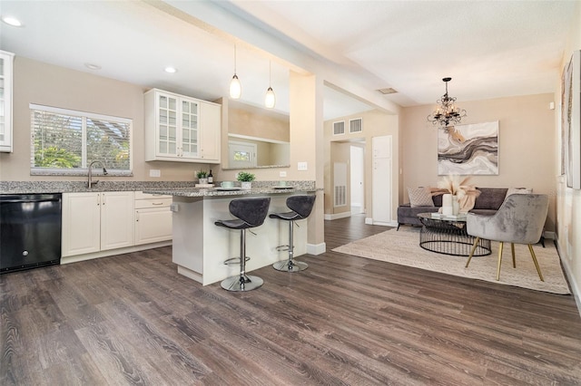 kitchen with glass insert cabinets, dark wood finished floors, dishwasher, a kitchen bar, and white cabinets