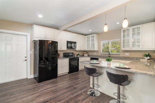 kitchen featuring dark wood finished floors, white cabinetry, a peninsula, and black appliances