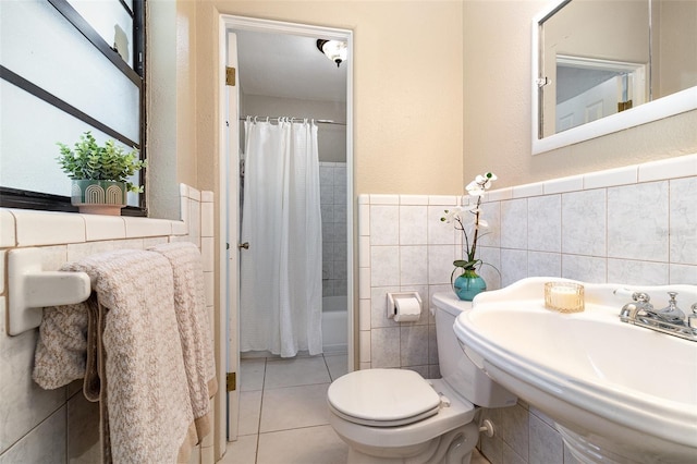 full bath featuring shower / bathtub combination with curtain, a sink, tile patterned flooring, tile walls, and toilet